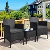 A black rattan furniture set with two chairs and a small table on a wooden deck, with a house and greenery in the background. Produktbild-Vorschau