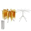 A white pasta drying rack with fresh pasta hanging from it, and another empty pasta drying rack, and a folded pasta drying rack. Produktbild-Vorschau