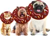 Three pets, a cat and two dogs, are wearing donut-shaped collars. Produktbild-Vorschau