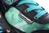 A close-up view of the upper part of a green and black inline skate with teal laces. Anteprima dell’immagine prodotto
