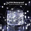 A glass of water filled with white LED string lights, with text overlay indicating waterproof features. Produktbild-Vorschau