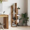A wooden bookshelf with various items placed on its shelves, next to a desk and a plant. Náhled obrázku produktu