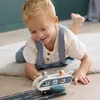 A young boy is playing with a toy airplane on the floor. Voir les images du produit