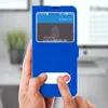 A person is holding a blue flip cover phone case with an incoming call displayed on the phone screen. Podgląd zdjęcia produktu
