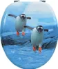 A toilet seat with a printed image of two penguins walking on rocks near water. Náhled obrázku produktu