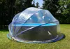 A transparent pool cover is set up over a round swimming pool in a grassy yard with trees in the background. Produktbild-Vorschau