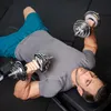 A man lying on a bench and doing dumbbell exercises. Náhled obrázku produktu