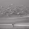Close-up of water droplets on a gray fabric surface, with a zipper visible in the foreground. Náhled obrázku produktu