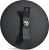 The back of a black, round object with a strap and a metal fastener. Produktbild-Vorschau