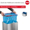 Hands are shown inserting a blue trash bag into a silver rectangular trash can. Produktbild-Vorschau