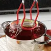 A close-up shot of a KADAX Einmachglas-Zange "Kaltag" being used to lift jars of jam out of a pot of boiling water. Anteprima dell’immagine prodotto