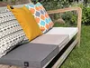 A close-up shot of colorful cushions and seat pads on a wooden outdoor bench. Náhled obrázku produktu