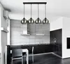 A modern kitchen with a black and gray color scheme, featuring a sleek island with chairs and a pendant light fixture. Náhled obrázku produktu
