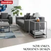 A modern living room setting with a sofa, coffee table, and a side table with a lamp. Anteprima dell’immagine prodotto