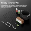 A collection of items for a grow kit laid out on a black surface. Voir les images du produit