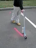 A person is using a marking stick on an asphalt surface with pink spray paint marks. Anteprima dell’immagine prodotto