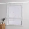 A white sheer Roman blind with a wavy sand-colored beaded pattern is installed on a window. A small vase with lavender and a decorative stone are on a wooden dresser to the left. Produktbild-Vorschau
