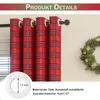 Close-up of red plaid curtains with a measurement detail of a curtain ring and a Christmas wreath in the background. Produktbild-Vorschau