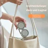 A person is holding a small, foldable fan over a light-colored tote bag. Náhľad obrázku produktu