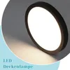A close-up shot of a round, black LED ceiling lamp with a bright white light emanating from its center, set against a gradient background that transitions from light gray to white. Náhľad obrázku produktu