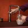 A person is filling a glass with water from a faucet. Anteprima dell’immagine prodotto