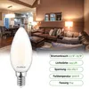A living room scene with a couch and lamps, with a product image of an LED bulb in the foreground. Produktbild-Vorschau
