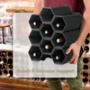 A person is holding a black modular wine rack filled with wine bottles. Produktbild-Vorschau