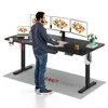 A man is standing at a black standing desk with multiple monitors and a laptop. The desk is on a gray mat with the brand name "SANODESK" printed on it. Podgląd zdjęcia produktu