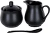 A black sugar bowl with a lid and a black creamer pitcher are displayed next to each other, with a black spoon below them. Produktbild-Vorschau