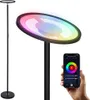 A modern RGB floor lamp with a smartphone app interface shown in the foreground. Produktbild-Vorschau
