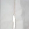 A close-up view of a cream-colored zipper on a fabric surface. Náhled obrázku produktu