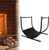 A black metal firewood rack is shown against a white background, with a partial view of a brick fireplace and logs on the left side of the image. Produktbild-Vorschau