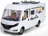 A white toy camper van with mountain graphics on the side, shown from a front-side angle on a white background. Voir les images du produit