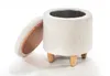 A white, fluffy round ottoman with wooden legs and an open lid, shown against a white background. Produktbild-Vorschau