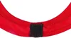 A close-up view of a red fabric item with a black velcro closure. Produktbild-Vorschau