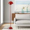 A red floor lamp stands next to a light gray sofa in a living room setting. Anteprima dell’immagine prodotto
