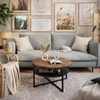 A living room scene with a light blue sofa, a round coffee table, and decorative items. Produktbild-Vorschau