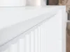 A close-up shot of a white cabinet with a fluted design on its door. Voir les images du produit