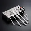 A set of silverware is displayed on a black surface, with the product packaging visible. Podgląd zdjęcia produktu