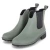 A pair of green Chelsea boots with black elastic side panels and black soles, presented on a white background. Anteprima dell’immagine prodotto