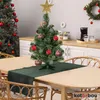 A small decorated Christmas tree sits on a table in a kitchen setting. Produktbild-Vorschau