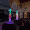 An outdoor patio at night, decorated with colorful string lights wrapped around columns and furniture. Náhled obrázku produktu