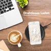 A flat lay of a laptop, a cup of coffee, and a smartphone charging wirelessly on a wooden desk. Produktbild-Vorschau
