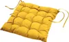 A yellow tufted seat cushion with ties, isolated on a white background. Podgląd zdjęcia produktu