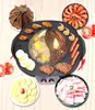 A top-down view of an electric grill pan with a hot pot in the center, surrounded by various food items like shrimp, sausages, steak, chicken wings, tripe, and sliced potatoes. Voir les images du produit