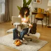A woman is working on her laptop while sitting on a chair with her dog next to her. Náhľad obrázku produktu