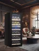 A modern wine cooler filled with bottles of wine in a luxurious living room setting. Produktbild-Vorschau