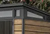 Close-up view of the corner of a modern garden shed, showing the wood-effect siding and dark grey trim with windows. Produktbild-Vorschau