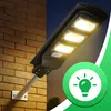 A solar street lamp is mounted on a brick wall, with a green circular graphic containing a lightbulb icon on the right side. Anteprima dell’immagine prodotto