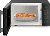 An open microwave with a dish of lasagna inside. Produktbild-Vorschau